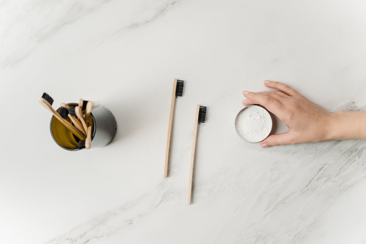 Flat lay of bamboo toothbrushes and eco-friendly dental powder emphasizing sustainable hygiene.